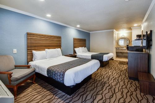 a hotel room with two beds and a chair at Americas Best Value Inn Richmond in Richmond