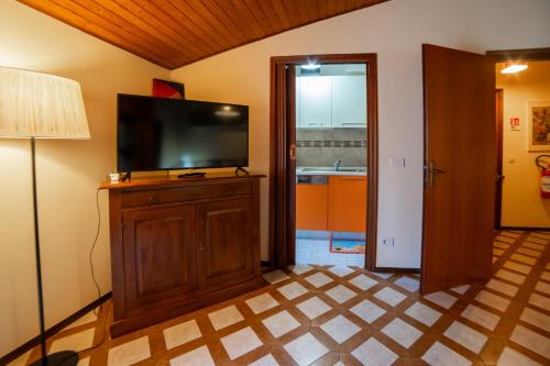 a living room with a flat screen tv on a wooden cabinet at Dolce Rifugio sul Castello - Incantevole appartamento a due passi dal centro con Garage in Sestola