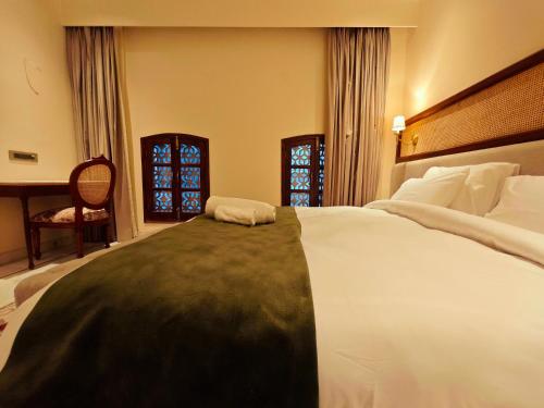 a bedroom with a large bed and a desk at Gauri Gangaa in Haridwār