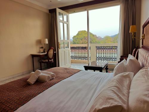 a bedroom with a large bed with a large window at Gauri Gangaa in Haridwār