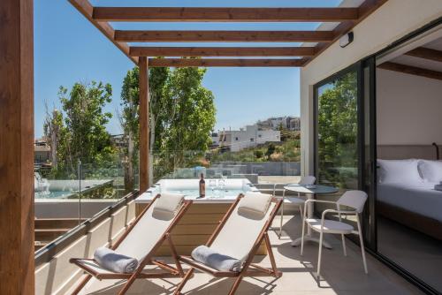 a room with a balcony with a table and chairs at VAYA Suites by Omilos Hotels in Amoudara Herakliou
