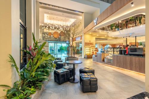 a shopping mall with a table and stools in it at Buri Sriphu Hotel in Hat Yai