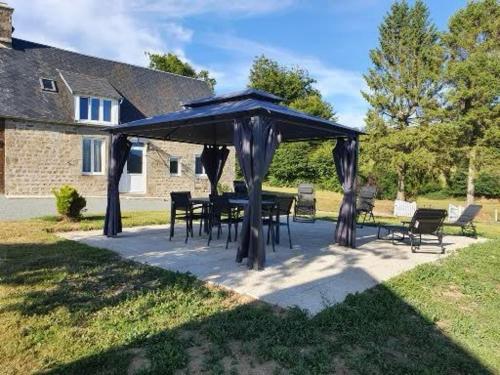 a table and chairs under a blue umbrella at Gîte du ronthaunay in Saint-Clément
