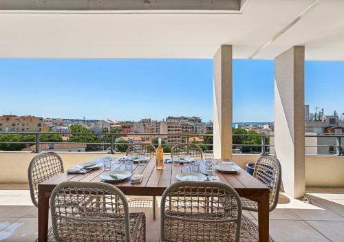 d'un balcon avec une table en bois et des chaises. dans l'établissement Duplex Elegante Vista Panorâmica 360 Juan-les-Pins, à Antibes