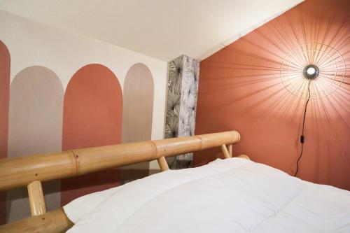 - une chambre avec un lit et un mur avec un parasol dans l'établissement L'escale Tropicale, Centre ville, à Mulhouse