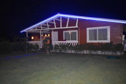 a red house with a blue light on it at night at Private pool with 3 bhk farm house Kuku farm stay # Moinabad in Venkatāpur