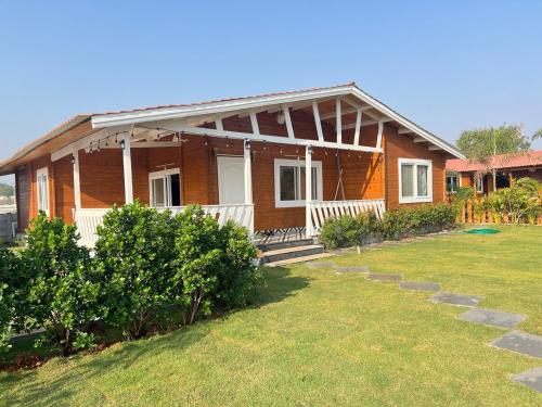 a house with a grass yard in front of it at Private pool with 3 bhk farm house Kuku farm stay # Moinabad in Venkatāpur