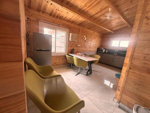 a kitchen with a table and chairs and a refrigerator at Private pool with 3 bhk farm house Kuku farm stay # Moinabad in Venkatāpur