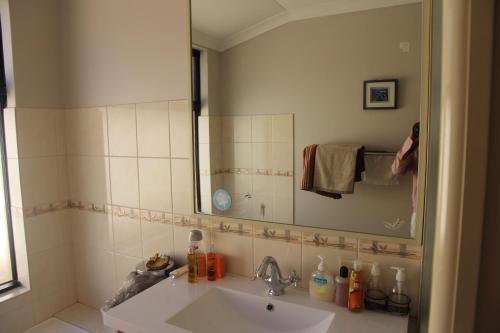 a bathroom with a sink and a mirror at Mimi's House in Perth