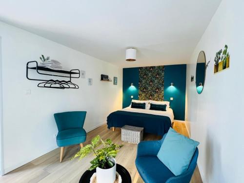 - une chambre avec un lit et deux chaises bleues dans l'établissement Les cottages de Fabienne et Orlando 10 personnes, à Calais