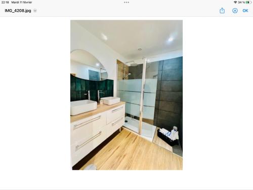 La salle de bains est pourvue de placards blancs et d'un miroir. dans l'établissement Les cottages de Fabienne et Orlando 10 personnes, à Calais