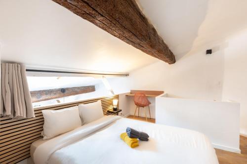 a bedroom with a large white bed and a chair at Le Van Gogh - Hypercentre - Clim - Wifi - 4 pers in Saint-Rémy-de-Provence