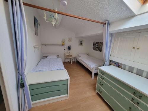 - une chambre avec 2 lits et une commode dans l'établissement Maison de vacances 6 couchages, 2 chambres, mezzanine, wifi, 100m de la plage residence VILLAGE MER LRVM26, à Portiragnes