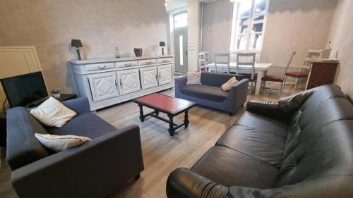 un salon avec deux canapés et une table dans l'établissement L'Ecole - Vue panoramique - À 50 m du Château, à Villeneuve