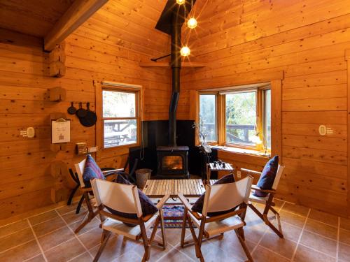 a living room with a fireplace in a log cabin at ALL SEASON RESORT No2 Torino Saezuri in Chōjamachi