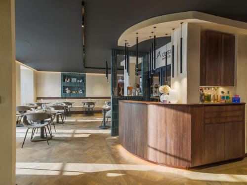 a restaurant with a bar with tables and chairs at Ma maison in Guémar