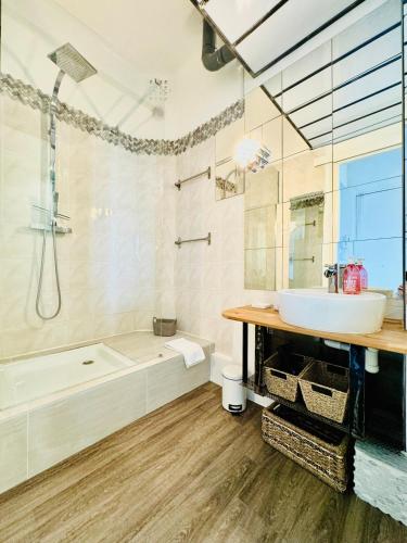 une salle de bain blanche avec une baignoire et un lavabo dans l'établissement Le Méditerranée - Apt 4 Pers - 200 m des plages, à Antibes