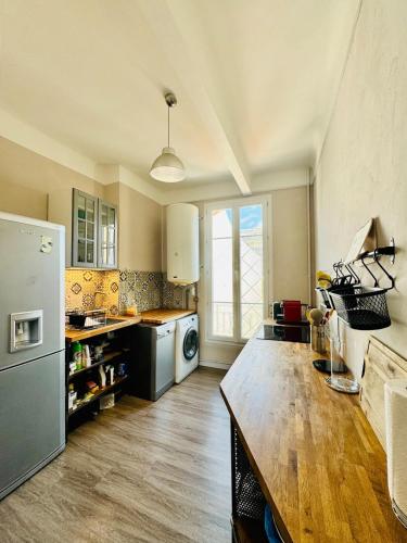 une cuisine avec un réfrigérateur et une table à l'intérieur dans l'établissement Le Méditerranée - Apt 4 Pers - 200 m des plages, à Antibes