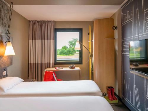 a hotel room with a bed and a window at ibis Pontorson Baie Du Mont Saint Michel in Saint-Georges-de-Gréhaigne