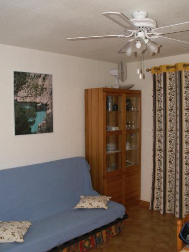 - une chambre avec un lit bleu et un ventilateur de plafond dans l'établissement B-Blue T2 vue mer, à Six-Fours-les-Plages