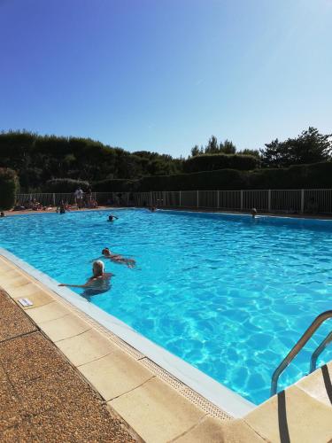 un groupe de personnes se baignant dans une grande piscine dans l'établissement B-Blue T2 vue mer, à Six-Fours-les-Plages