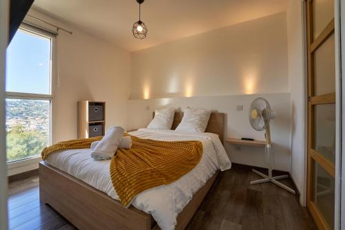 une chambre avec un grand lit et une fenêtre dans l'établissement Saint-Mandrier - Vue Mer, Piscine & Sérénité, à Saint-Mandrier-sur-Mer