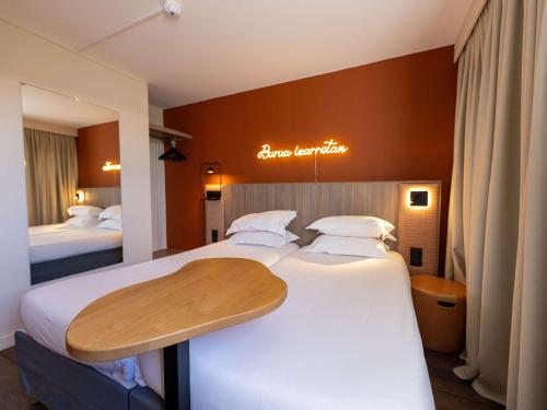 a hotel room with two beds and a sign on the wall at Hotel Donibane Saint-Jean-de-Luz in Saint-Jean-de-Luz