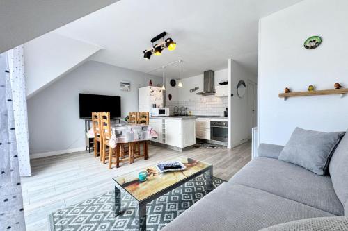 un salon avec un canapé et une table dans l'établissement Charmant T2 cosy - Balcon - 300m des plages, à Larmor-Plage