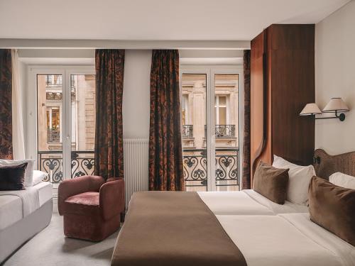 a hotel room with a bed and a chair and windows at Hôtel Belloy in Paris