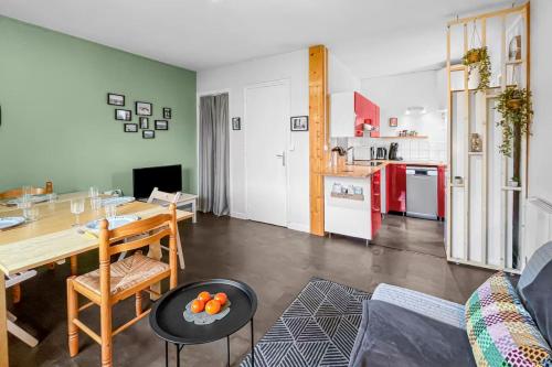 un salon avec une table et une cuisine dans l'établissement Bright apartment - near the beach, à Merville-Franceville-Plage