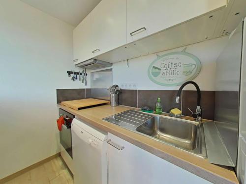 une cuisine avec un évier et un plan de travail dans l'établissement Appartement 2 piéces 4 couchages ULYSSE PORT LEUCATE NATURISME PL080-TB38, à Leucate-Plage