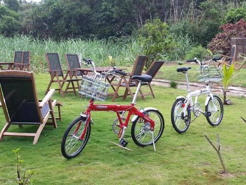 two bikes parked in the grass next to chairs at Minshuku Myojoso in Yoron