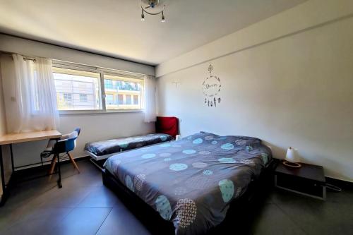 une chambre avec un lit, un bureau et une fenêtre dans l'établissement Les Petites Alpes - Apt 5 Prs - 3 min des plages - climatisation, à Antibes