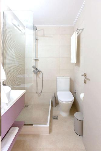 a bathroom with a shower and a toilet and a sink at Azari Lifetime Memories in Paralion astros