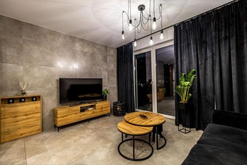 een woonkamer met een tafel en een tv bij Exclusive place with underground parking and terrace in Oświęcim