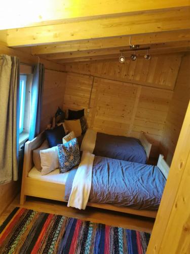 a bed in a room in a log cabin at Stuga Mörtbäcken in Koppom