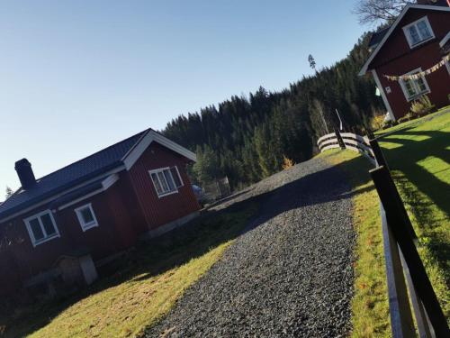 a house on a hill with a fence next to it at Stuga Mörtbäcken in Koppom