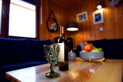 a bottle of wine and a glass on a table at Tylko tu Bieszczady, Balia, Sauna in Baligród