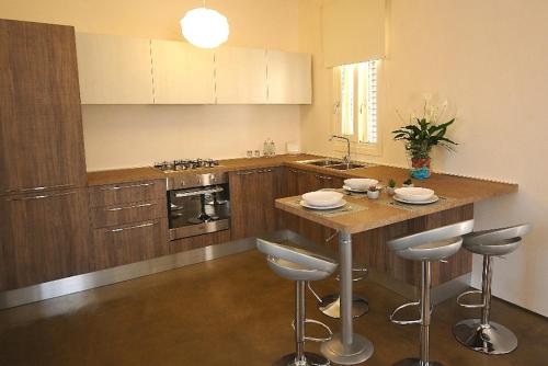 a kitchen with a island with bar stools in it at Villa Elen in Marsala