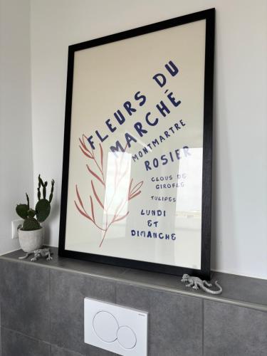 a framed picture on a shelf with a plant at Penthouse-Wohnung mit Flussblick in Oldenburg