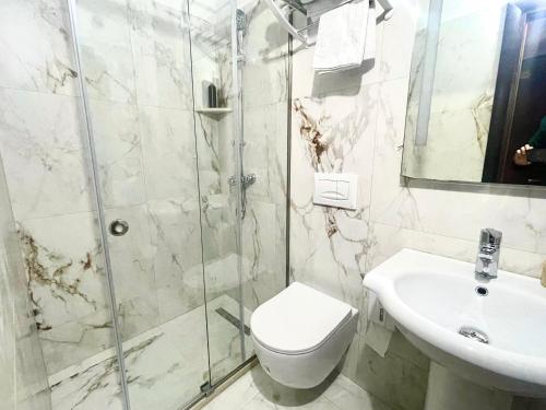 a bathroom with a shower and a toilet and a sink at City 5 Hotel in Tirana