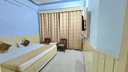 a bedroom with a bed and a television in a room at Hotel Akashdeep in McLeod Ganj