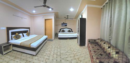 a hotel room with two beds and a couch at Hotel Akashdeep in McLeod Ganj