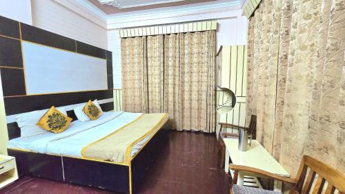 a bedroom with a bed and a desk in it at Hotel Akashdeep in McLeod Ganj
