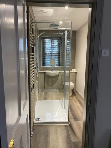 a bathroom with a glass shower and a sink at Abbey House Charming traditional historic house in Jedburgh