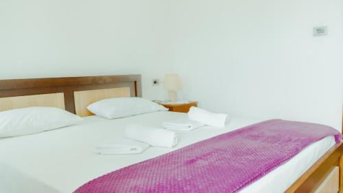 a bedroom with a bed with a purple blanket on it at Guesthouse Shtino in Gjirokastër