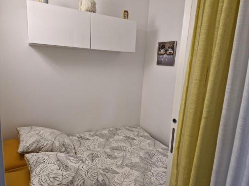 Cette petite chambre comprend un lit et une armoire blanche. dans l'établissement Sol-y-Days Tahiti, Studio Cab 4PERS à 100m de la plage, à La Grande Motte