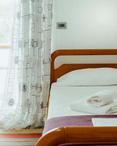 a bedroom with a bed with a white curtain at Guesthouse Shtino in Gjirokastër