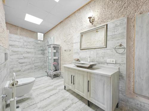 a white bathroom with a tub and a sink at Karlık Cave Suite Cappadocia in Uchisar