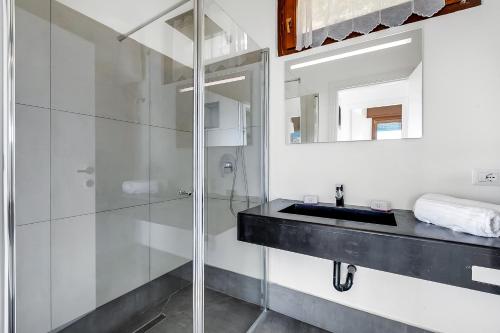 łazienka z przeszkloną kabiną prysznicową i umywalką w obiekcie Casa dei Nonni Apartments w Tremosine Sul Garda